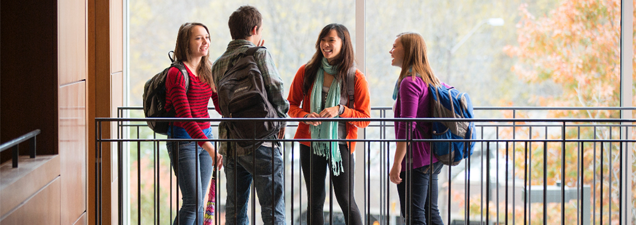 Group of students talking near a railing