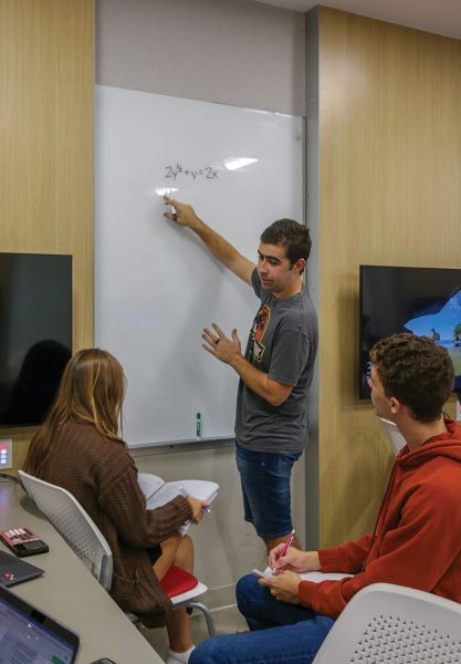 Student at a whiteboard helps other students in class